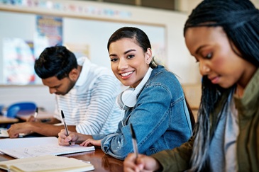 Three international students in a study group making notes whilst thinking about internships.