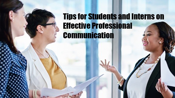 A confident female intern holding a report is communicating effectively with a female supervisor and a colleague next to a large window in an office.