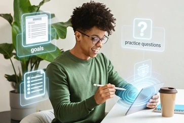 A young student is sitting by a desk with his tablet thinking and preparing for an interview training session with virtual icons of practice questions, CV and goals coming out of his tablet.